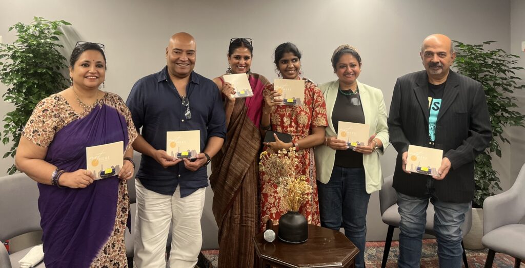 Contributors and writers of notHERE posing with copies of the book after the Gurugram reading